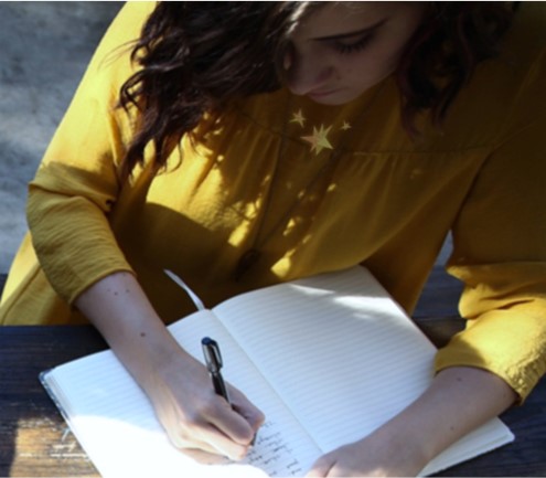 girl sitting at a table, journaling